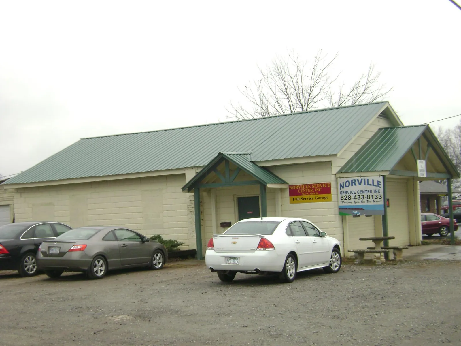 Green metal roof on a service garage with a covered entry in Mango