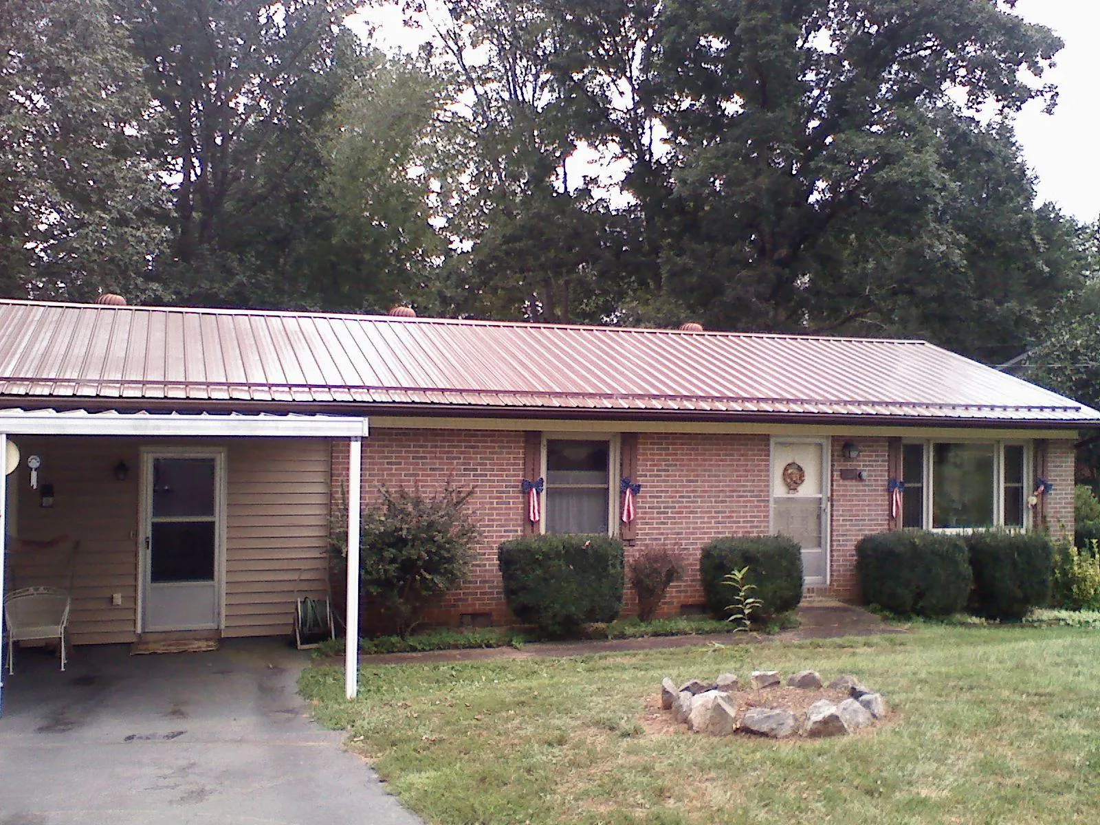 Bronze metal roof and carport on a brick ranch home — Roof Repair work by our crew in Mango